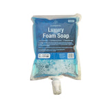 A 1-litre pouch of Puregiene Luxury Foam Soap with a blue label, white soap foam visible at the bottom, and a dispensing nozzle attached.